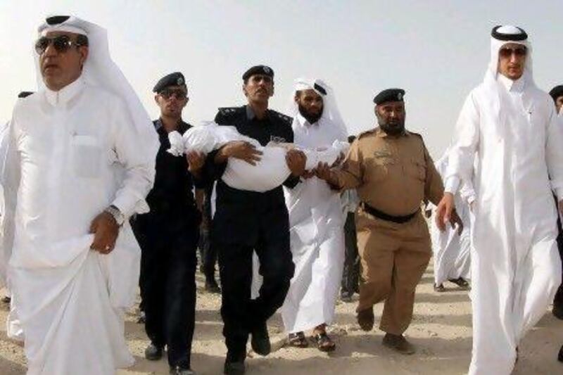A Qatari carries the body of one of the 19 victims who died in a nursery when a fire swept through Doha's Vellaggio Mallg mall last week.