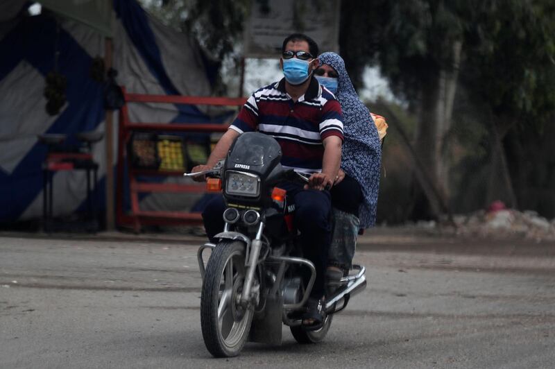 A man wearing a protective face mask to prevent the spread of the coronavirus disease (COVID-19) rides a motorcycle with his wife in Abu Kabir, Sharqia Governorate, north of Cairo, Egypt June 13, 2020. REUTERS/Amr Abdallah Dalsh
