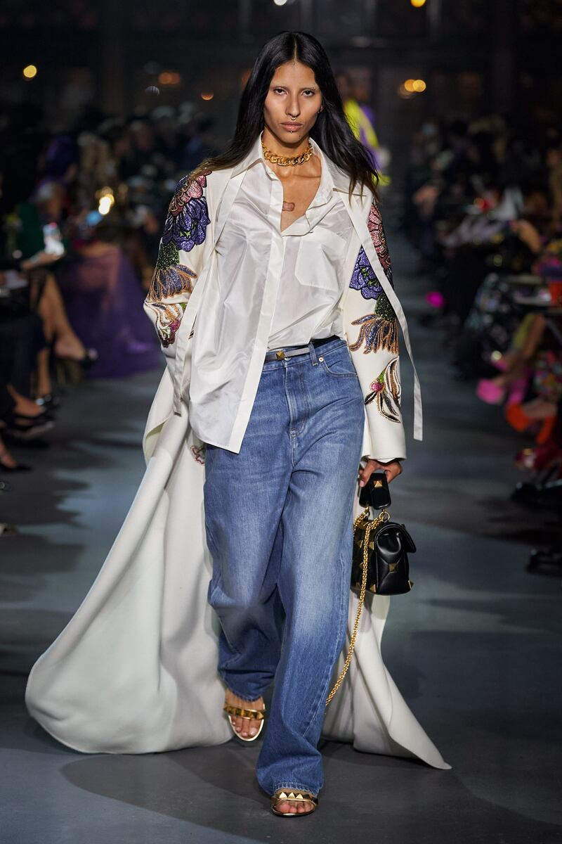 An embroidered cape is worn with an untucked silk shirt at the Valentino spring/summer 2022 show