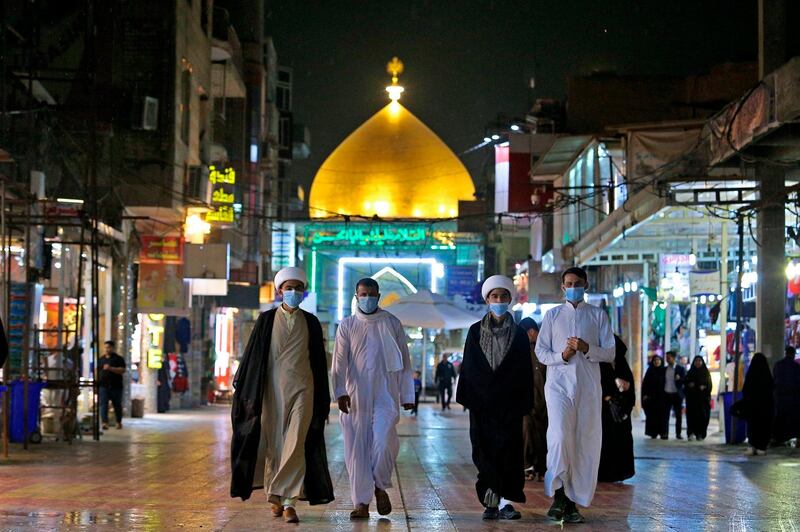 Shiite pilgrims walk outside the shrine of Imam Ali in Najaf, Iraq, Feb. 24, 2020. AP Photo