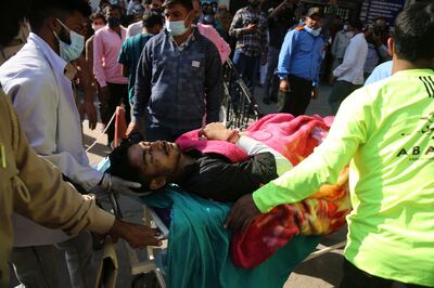 An injured passenger is brought to a hospital for treatment in Jammu, after Thursday's bus accident. AP