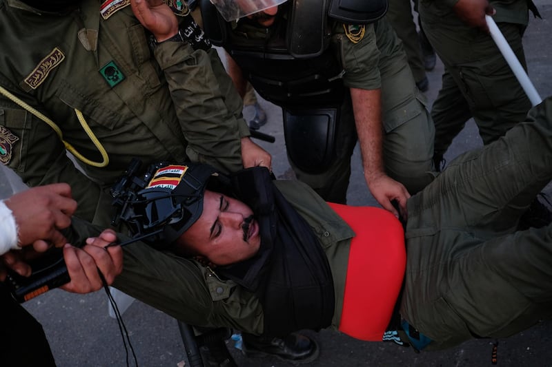 An anti-riot police officer injured during clashes is moved to safety. Getty