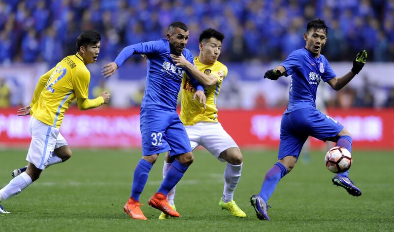 (FILES) This file photo taken on March 5, 2017 shows Shanghai Shenhua's Argentine striker Carlos Tevez (2L) fighting for the ball with Yang Xiaotian (2R) of Jiangsu Suning during their Chinese Super League football match in Shanghai.
Carlos Tevez faced growing calls on June 19, 2017 to be shipped out as angry Shanghai Shenhua fans turned on him and under-pressure manager Gus Poyet. / AFP PHOTO / STR / China OUT