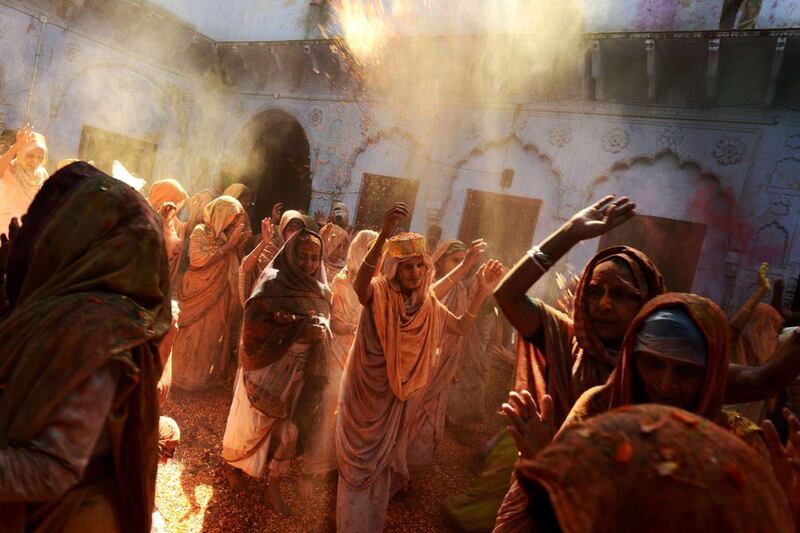 Indian widows throw coloured powder and flower petals as they dance during Holi celebrations at an ashram in Vrindavan. Chandan Khanna / AFP Photo