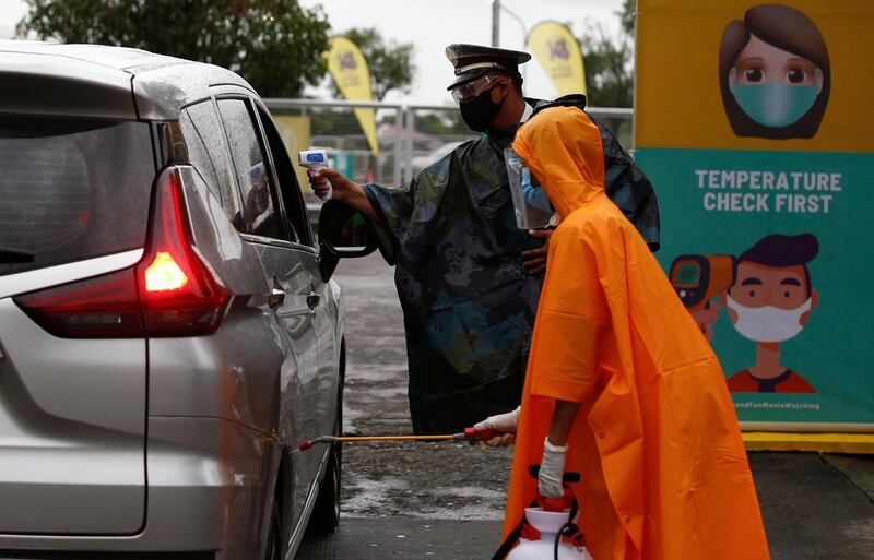 A security officer conducts a thermal check on a passenger at the SM City Pampanga mall in Pampanga province, Philippines. EPA