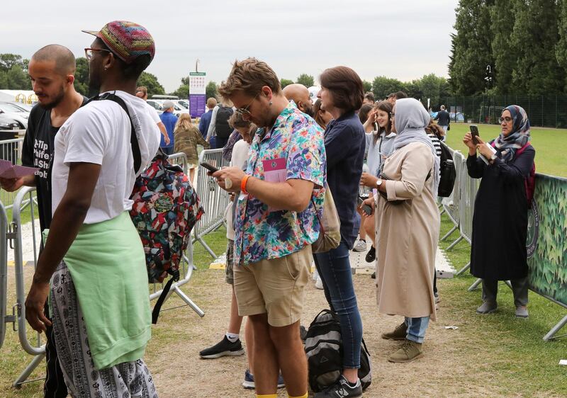 In this Tuesday, July 9, 2019, tennis fans wait in a queue to get tickets to enter the Wimbledon Tennis Championships in London. For many the Wimbledon experience starts in a tent as they gather in a small park across from the tournament grounds to camp out, some for days, in the hope of getting a ticket to Centre Court as they are released each day. "The Queue" is a decades-old tradition that has grown to become its own phenomenon.(AP Photo/Natasha Livingstone)
