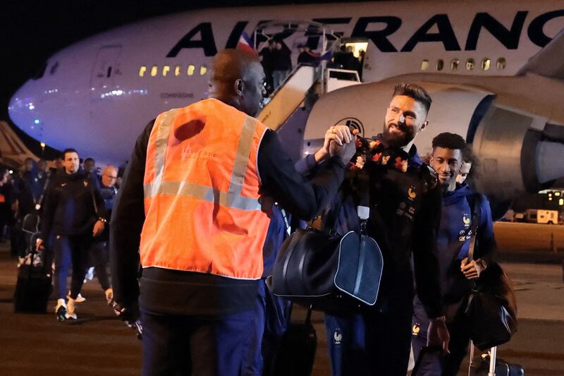 France forward Olivier Giroud shakes hands with an airport employee. AFP