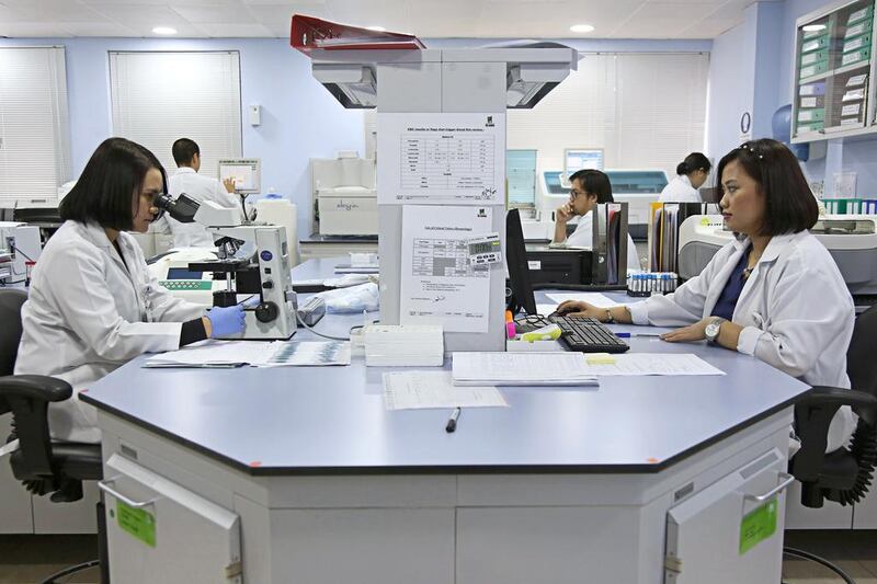 Staff work at the hematology unit of Al Borg Medical Laboratories in Abu Dhabi. Irene García León for The National