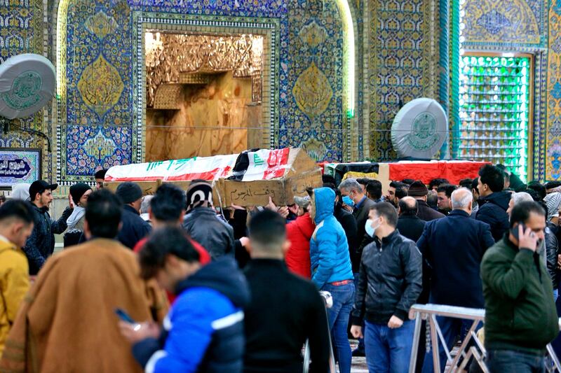 Mourners carry flag-draped coffins of victims at the Imam Ali shrine in Najaf, Iraq.   AP