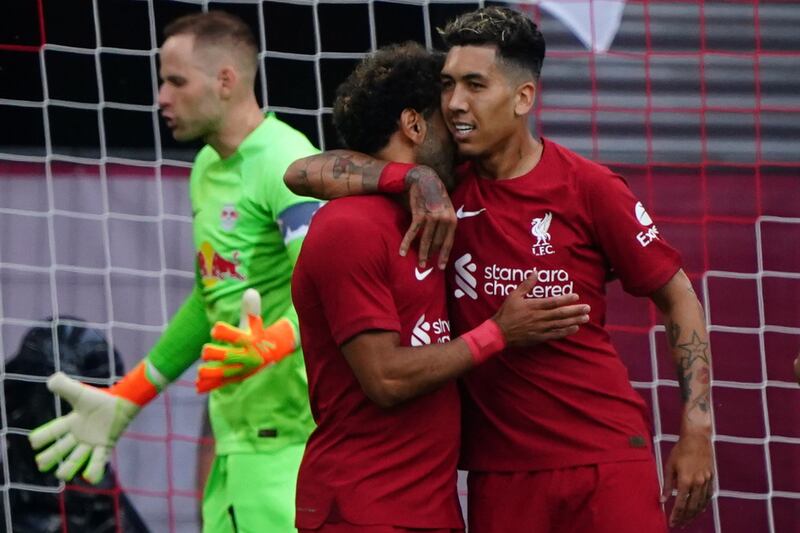 Liverpool's Mohamed Salah celebrates with Roberto Firmino. EPOA