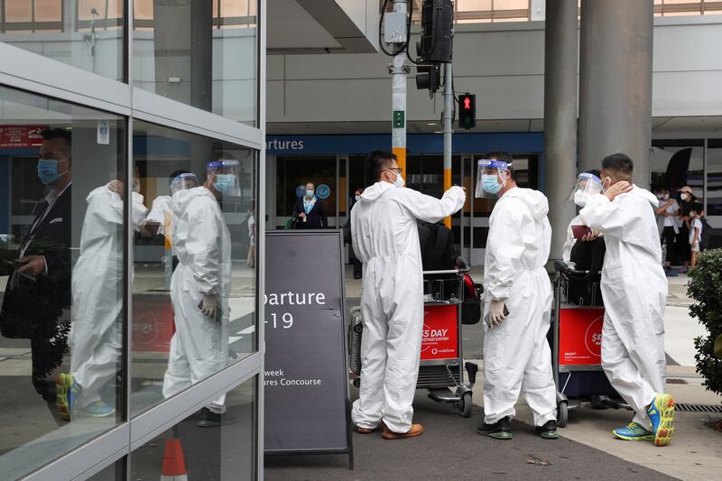 Travellers wear personal protective equipment outside the international terminal at Sydney Airport, Australia. Reuters