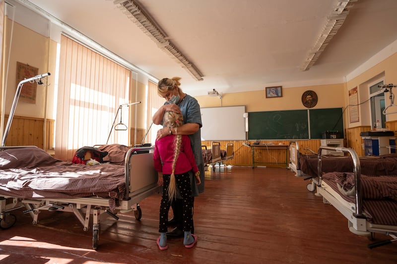 Nadia holds her 10-year-old granddaughter, Zlata Moiseinko, who suffers from a chronic heart condition, as she receives treatment at a schoolhouse that has been converted into a field hospital in Mostyska, western Ukraine. AP