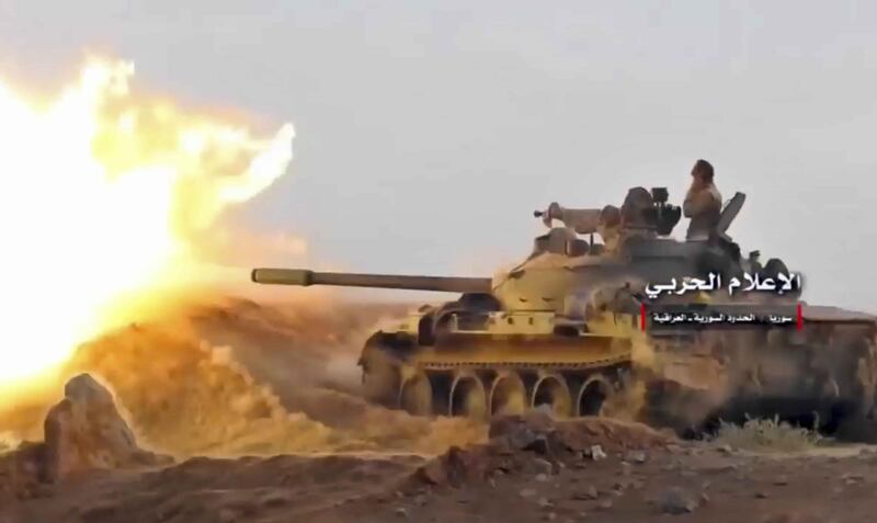 This frame grab from video provided Wednesday, Nov 8, 2017 by the government-controlled Syrian Central Military Media, shows a tank firing on militants' positions on the Iraq-Syria border. The Britain-based Syrian Observatory for Human Rights, said that Islamic State militants have withdrawn from their last stronghold following a government offensive and that government forces and allied troops, including Iraqi fighters are combing Boukamal, a strategic town on the border with Iraq, Thursday. (Syrian Central Military Media, via AP)