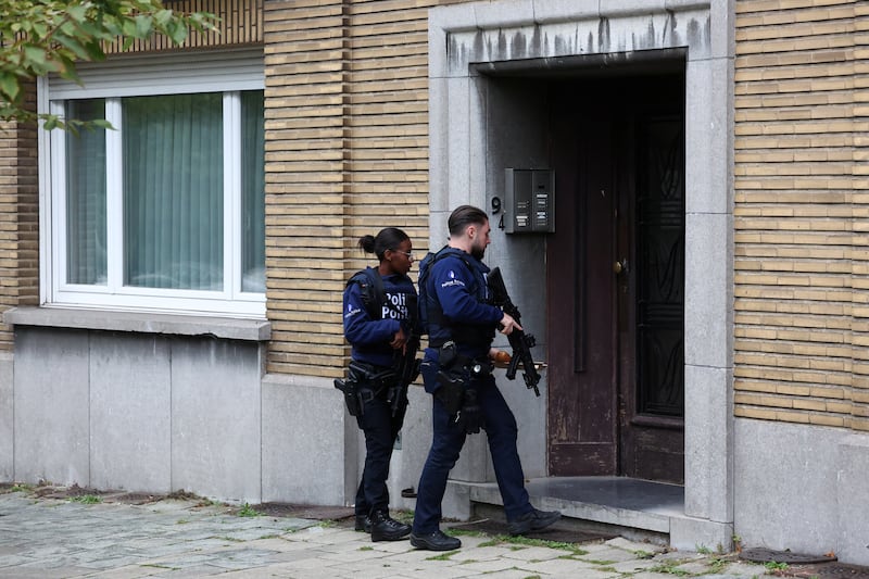 Police officers enter a building in Schaerbeek. Reuters