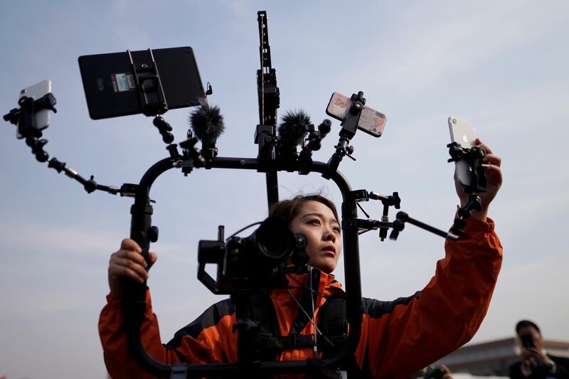 A media reporter uses mobile phones to do live broadcast during the second plenary session of the 13th National People's Congress (NPC) outside the Great Hall of the People  in Beijing, China. EPA