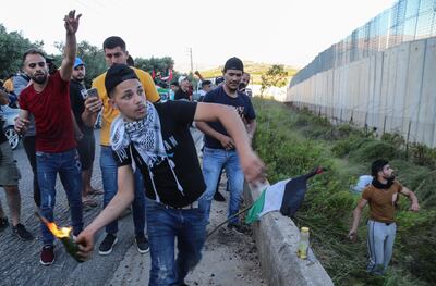 epa09202996 A supporter of Hezbollah and the Palestinian revolution faction prepare to throw a petrol bomb during protest at the Al Odaisseh area opposite the Al-Mutaleh Israeli settlement at the Lebanese border with Israel, 15 May 2021. People protested to support Palestinians following the past violence which has, according to local health authorities killed at least 139 people in Gaza and 7 in Israel.  EPA/NABIL MOUNZER