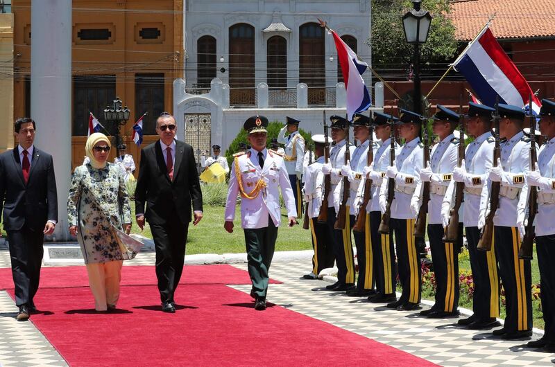 A handout photo released by the Turkish Presidential Palace Press Office shows Recep Tayyip Erdogan and his wife Emine reviewing a guard of honour upon his arrival at the presidential palace in Asuncion. AFP