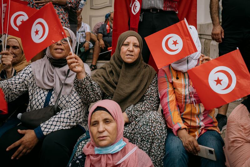 Protesters wave Tunisian flags and sing the national anthem at Sunday's protest in Tunis. Photos: Erin Clare Brown / The National