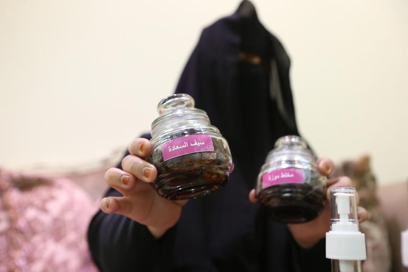 Umm Hamad holding one of her popular perfumes, Saif, which is named after her late husband. Fatima Al Marzooqi / The National