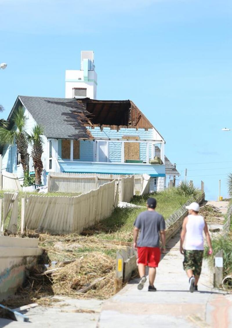 A Daytona Beach, Florida, ocean front home is missing a large portion of its roof, lost during Hurricane Matthew. Charles King / Orlando Sentinel via AP