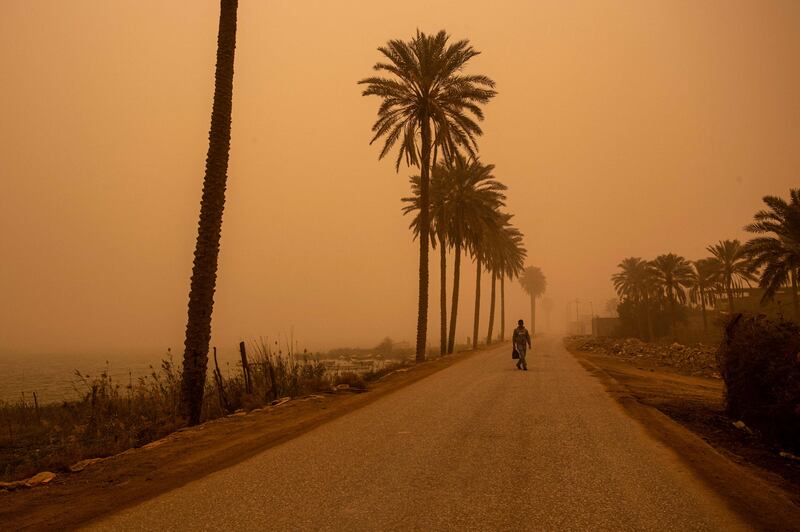 A man walks along a road during a sand storm in Iraq's southern port city of Basra. AFP