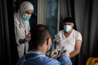 Lebanese health workers see a patient during the vaccination campaign at Rafik Hariri University Hospital in Beirut, Lebanon, on March 30, 2021. Getty