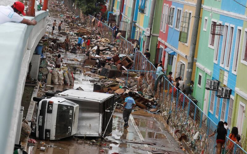 A vehicle lies on its side among debris along a road after flash floods brought by continuous monsoon rains in Marikina, Metro Manila. Reuters