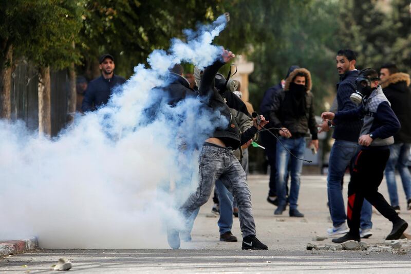 A Palestinian protester hurls back a tear gas canister fired by Israeli troops during clashes at a protest against US president Donald Trump's decision to recognise Jerusalem as the capital of Israel, in the West Bank city of Bethlehem on December 7, 2017. Mussa Qawasma / Reuters