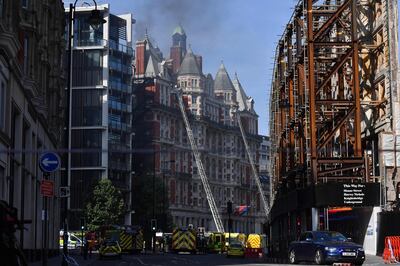 Firefighters tackle a blaze at the Mandarin Oriental hotel in central London on June 6, 2018. A fire broke out at London's Mandarin Oriental hotel, with dozens of firefighters deployed to tackle the blaze that pumped smoke high into the air over the British capital. / AFP / Ben STANSALL
