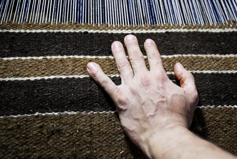 The hand of a man is seen as he weaves a traditional Egyptian rug in a textile workshop in the village of Atmida, in Dakahliya governorate, Egypt. Reuters