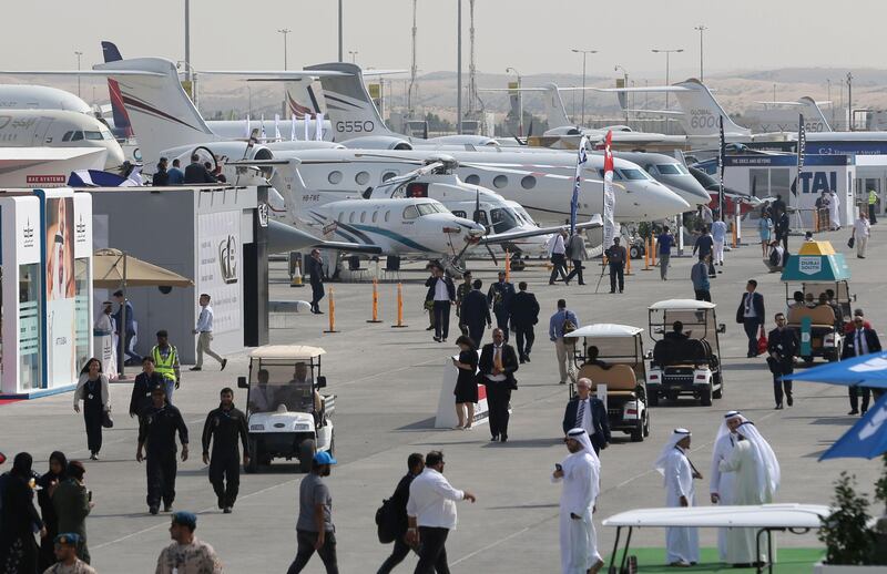 Participants walk past aircraft during the Dubai Airshow on November 12, 2017. Karim Sahib / AFP