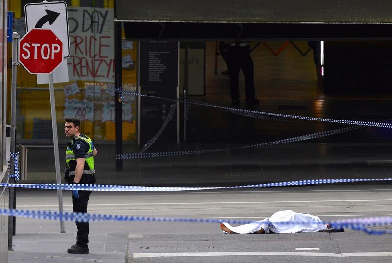 A policeman stands near a body covered with a sheet near the Bourke Street mall. AAP / Reuters