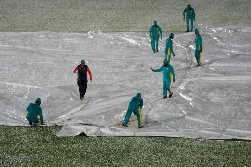 Ground staff cover the pitch after heavy hailstones rain stop the play of fourth Twenty20 cricket match between Pakistan and New Zealand, in Rawalpindi, Pakistan, Thursday, April 20, 2023.  (AP Photo / Anjum Naveed)