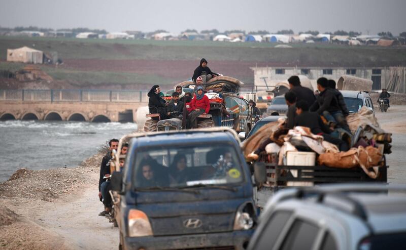 Displaced Syrians pass through the village of Deir al-Ballut in Afrin's countryside along the border with Turkey.  AFP