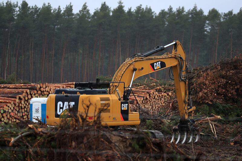 A Caterpillar Inc. excavator stands beside log piles of freshly felled pine trees during forest clearing work for the Tesla Inc. Gigafactory in Gruenheide, Germany, on Sunday, Feb. 23, 2020. Tesla Inc. has overcome a legal roadblock standing in the way of Elon Musk's plan to build an electric-car factory in Germany. Photographer: Krisztian Bocsi/Bloomberg