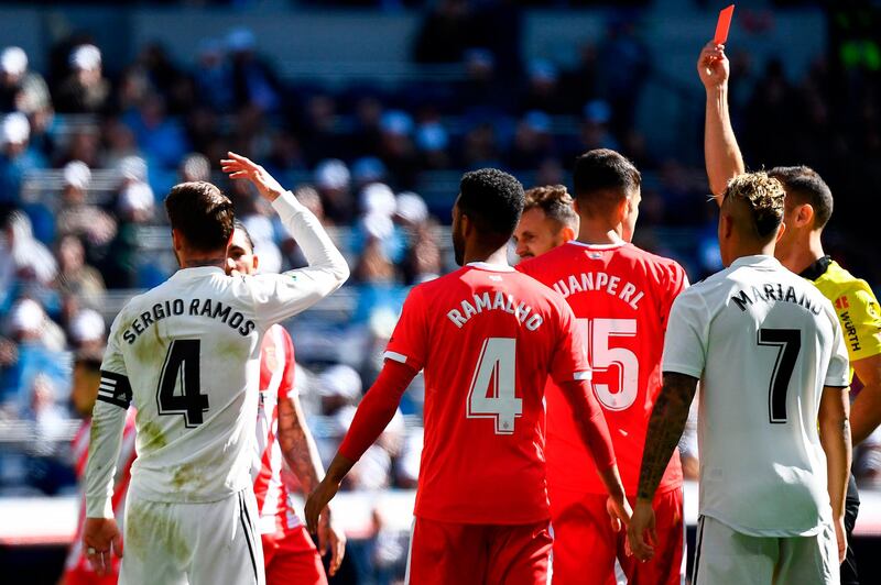Real Madrid's Spanish defender Sergio Ramos (L) reacts as he is shown a red card by Spanish referee Guillermo Cuadra Fernandez (R) during the Spanish League football match between Real Madrid and Girona at the Santiago Bernabeu stadium in Madrid on February 17, 2019. / AFP / GABRIEL BOUYS                     
