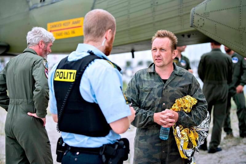 (FILES) This file photo taken on August 11, 2017 shows Peter Madsen (R), builder and captain of the private submarine "UC3 Nautilus" talking to a police officer in Dragoer Harbor south of Copenhagen, following a major rescue operation after the submarine sank in the sea outside Copenhagen Harbor.
Danish prosecutors on January 16, formally charged inventor Peter Madsen with last year's murder of Swedish journalist Kim Wall, whose dismembered body parts were found at sea after she interviewed him on his homemade submarine. Madsen, who was arrested and detained shortly after Wall's disappearance in August, has admitted cutting up her body and dumping it at sea but has denied intentionally killing her.
 / AFP PHOTO / Scanpix Denmark / Bax Lindhardt / Denmark OUT