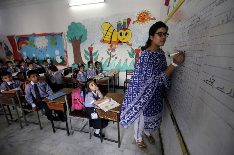 epa06244021 A Pakistani school teacher instructs children at a school, a day ahead of World Teacher's Day, in Peshawar, Pakistan, 04 October 2017. The World marks on 05 October a day to highlight teachers' central role in guiding children, youths, and adults through the life-long learning process.  EPA/BILAWAL ARBAB