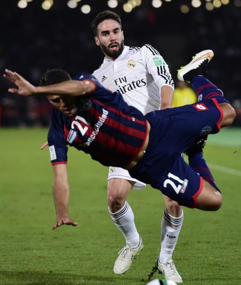 San Lorenzo’s defender Emmanuel Mas (front) falls while confronting Real Madrid’s defender Dani Carvajal during their FIFA Club World Cup final football match at the Marrakesh stadium in the Moroccan city of Marrakesh on December 20, 2014. AFP PHOTO / JAVIER SORIANO