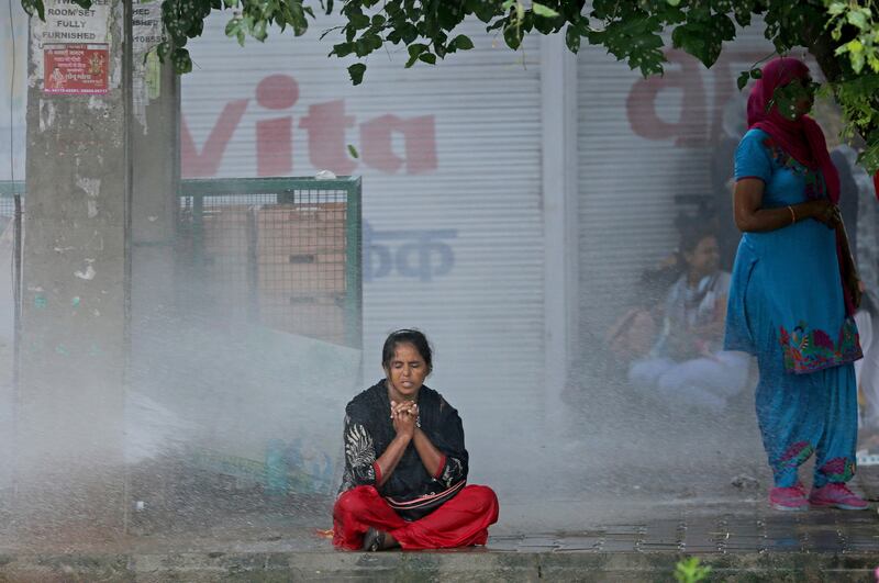 A  supporter is blasted by a water cannon. Altaf Qadri / AP Photo