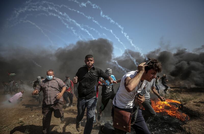epa06795301 Palestinians protesters run for cover from Israeli tear-gas during the clashes after Friday protest near the border east Gaza City on, 08 June 2018. Reports state that a twelve year old boy and other three Palestinians were killed and more than 600 protesters were wounded during the clashes near the border eastern Gaza Strip. Protesters plan to call for the right of Palestinian refugees across the Middle East to return to homes they fled in the war surrounding the 1948 creation of Israel.  EPA/MOHAMMED SABER