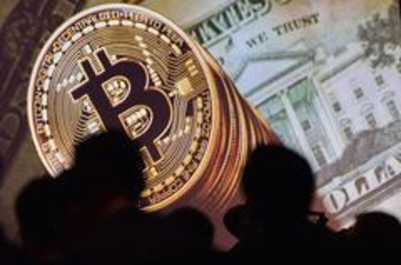 Bitcoin and US currencies is displayed on a screen as delegates listen to a panel of speakers during the Interpol World Congress in Singapore.  AFP