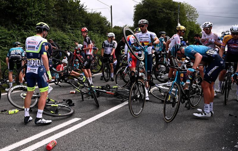 Riders on the side of the road after a mass crash during the first stage of the Tour de France.