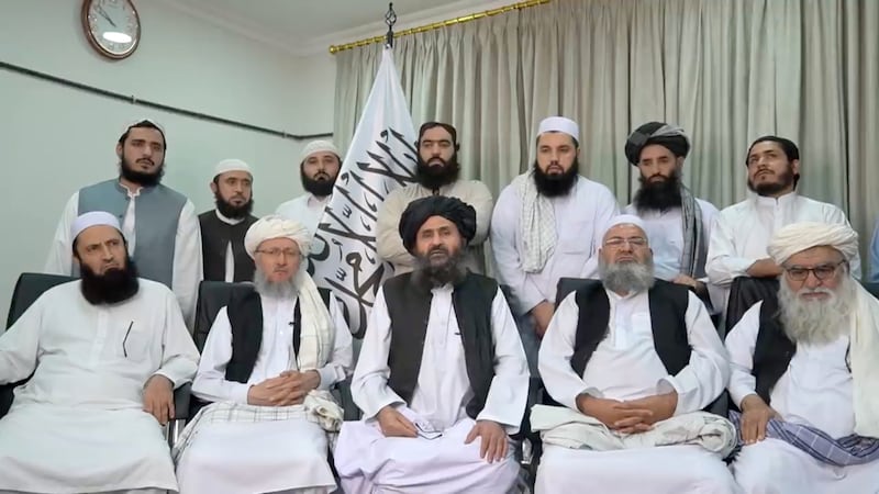 Baradar Akhund, a senior official of the Taliban, with a group of men, makes a video statement.