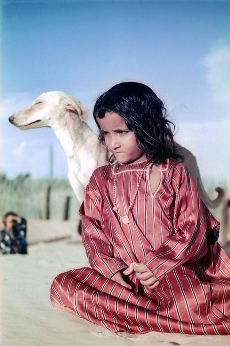 A girl, her saluki and a new dress in Liwa, 1953. Courtesy Ronald Codrai / TCA Abu Dhabi