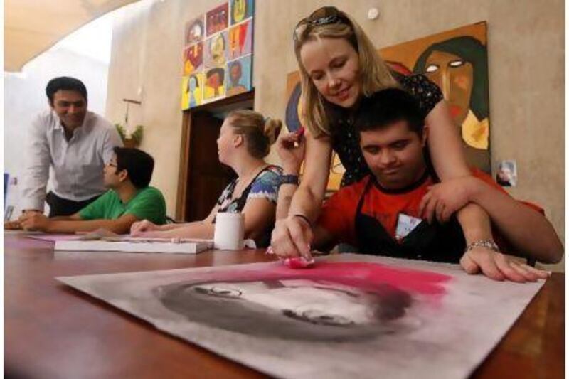 Sonja Tatton helps Umer Shuja, 22, with an artwork at the studio in Dubai.