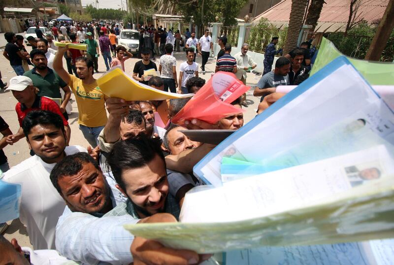Iraqi protesters hand over job requests to government employees in Basra, Iraq July 18, 2018.  REUTERS/Essam al-Sudani