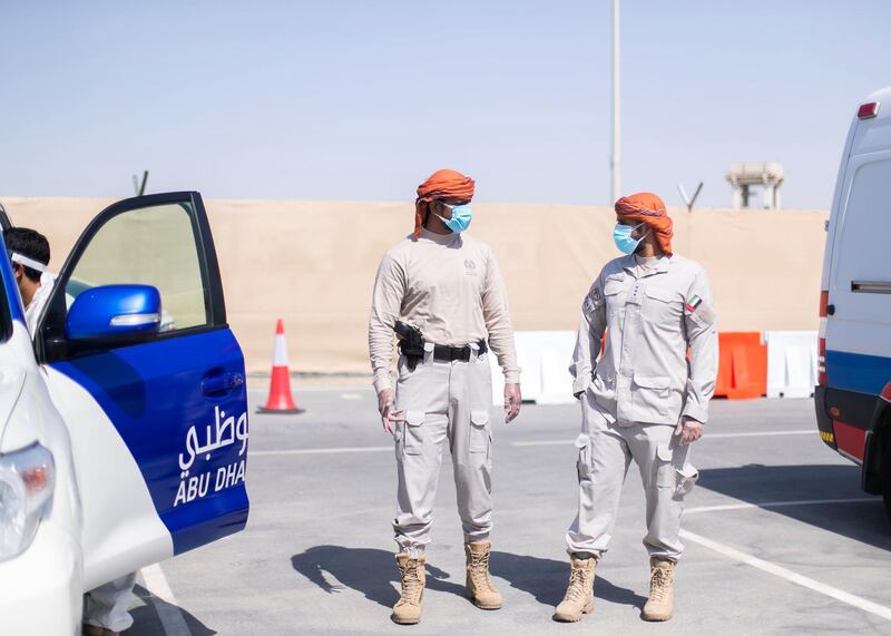 ABU DHABI, UNITED ARAB EMIRATES. 22 APRIL 2020. 
Police Special Patrols Unit Al Mersad dress up in their safety gear, before distributing masks to men lined up at Mussafah’s Covid test center.

(Photo: Reem Mohammed/The National)

Reporter:
Section: