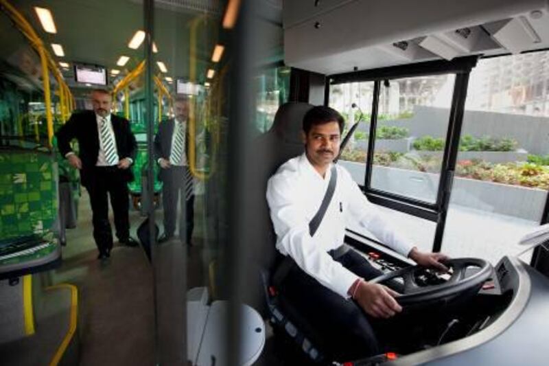 MAN Truck & Bus Group specialist driver Lakshamanan, at right, drives as the company's Senior Product manager Thomas Schweiger ride the new natural-gas powered bus on Tuesday, Dec. 20, 2011, in Abu Dhabi. The company and theAbu Dhabi Department of TRansportation has agreed to a trial run for the one-of-a-kind bus in Abu Dhabi, which will start tomorrow and run the Route 5, Abu Dhabi Mall to Marina Mall. The trial will last about 4 months so the bus can reach the hot months of the summer. It has been specially adapted to the UAE's specific climate conditions. According to the company representatives, the bus rates better Euro 6 standard emission test. (Silvia Razgova/The National)
