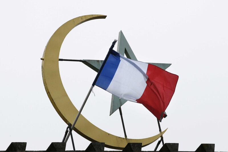 A French national flag is flown on top of the Grand Mosque of Paris, in Paris on November 27, 2015  in memory of the 130 victims of the November 13, 2015 coordinated terror attacks in Paris claimed by the Islamic State group (IS). A solemn ceremony was held for the victims of the Paris attacks, with President Francois Hollande vowing that France would respond to the "army of fanatics" with more songs, concerts and shows. "We will not give in either to fear or to hate," said Hollande in the courtyard of the Invalides buildings in central Paris, speaking to 2,000 dignitaries and those injured in the violence. (Photo by PATRICK KOVARIK / AFP)
